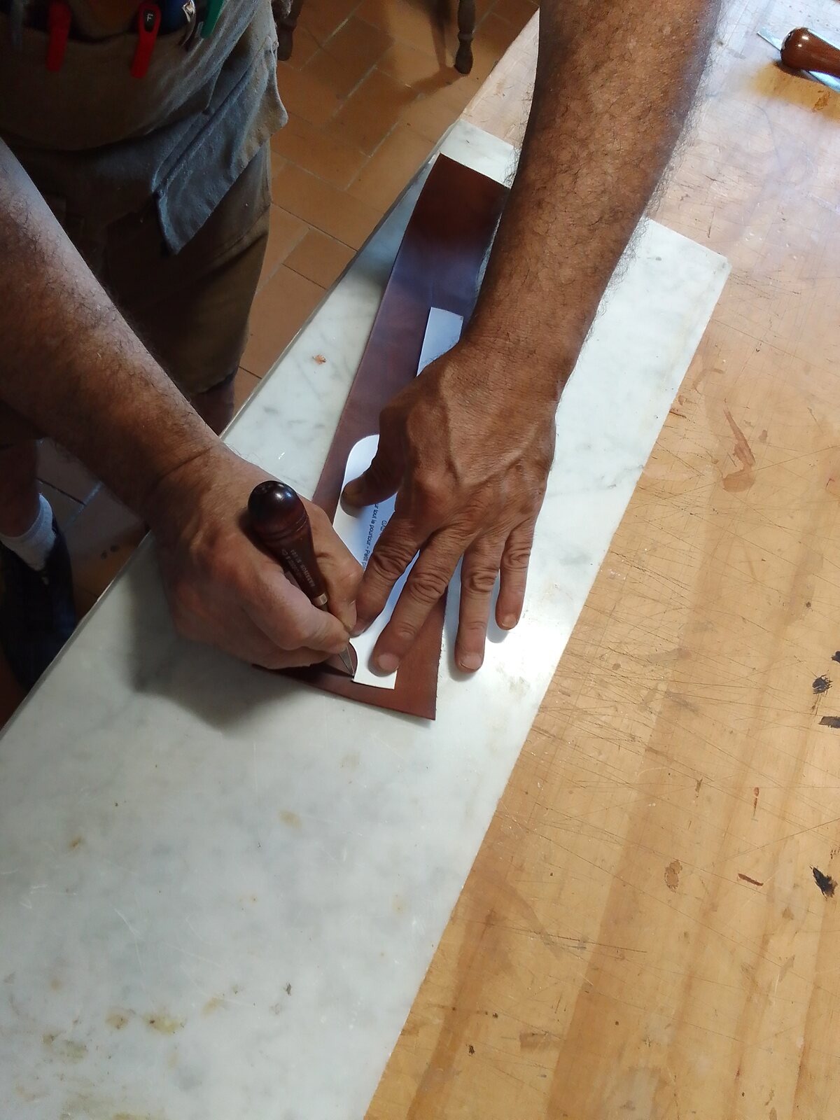 Traçage manuel d’une pièce de cuir dans l’atelier Art’Illium